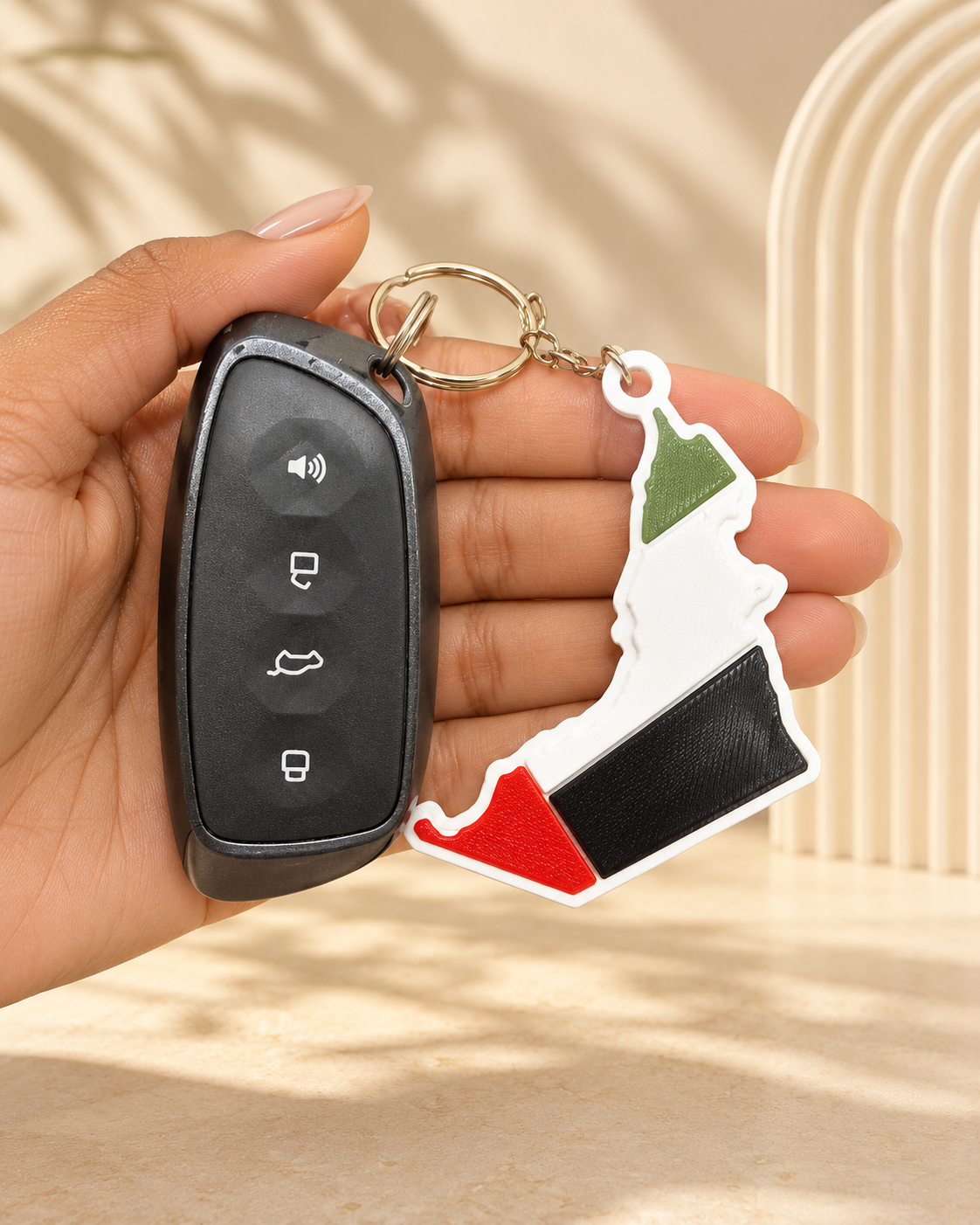 ميدالية خريطة الإمارات – في اليد مع مفتاح السيارة